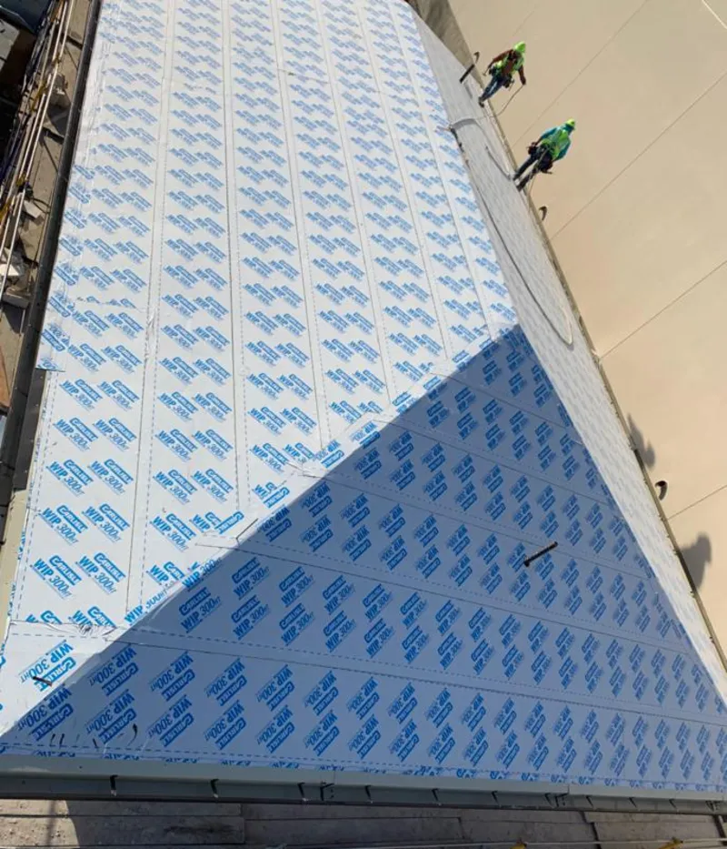 Professional roofers installing underlayment on a metal roof in Mission Viejo